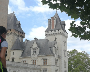 Une fille se balade avec son gros sac devant le château de pau